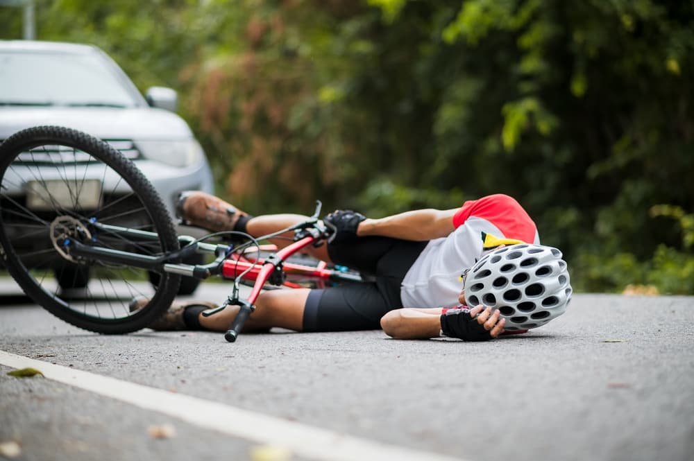 An Asian mountain biker was injured in a road collision with a car, highlighting the importance of accident prevention and road safety measures.